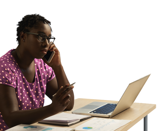 Mulher empreendedora em uma chamada de telefone e trabalhando em frente ao seu computador e sua mesa de trabalho